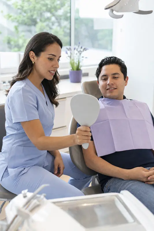 Dentista conversando con su paciente en el consultorio